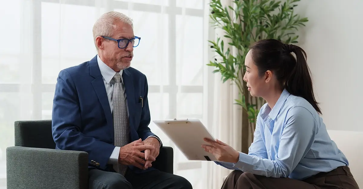 Insurance broker meeting a client at a desk in a modern office