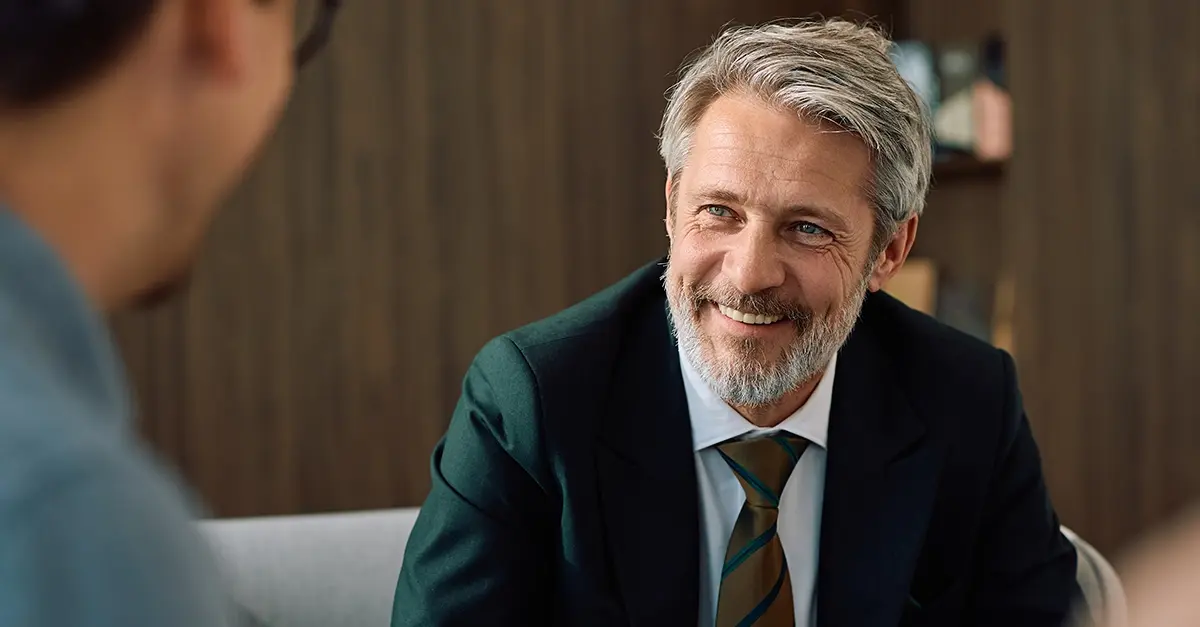 Investment manager meeting a client at a desk in a modern office