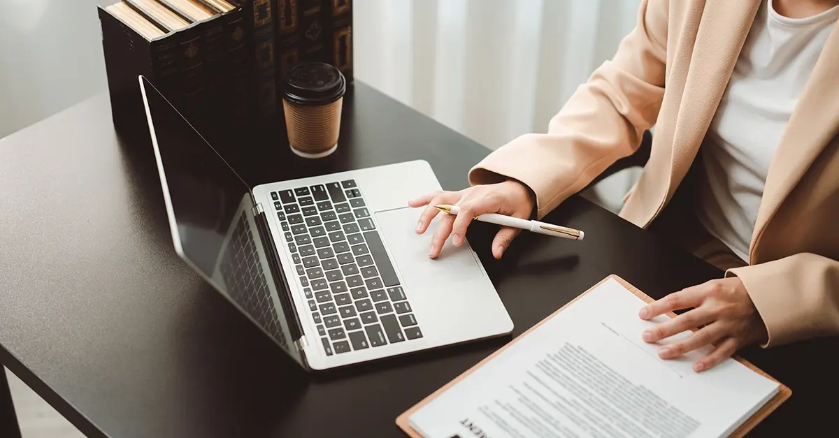 A compliance officer at a laptop reviewing training records in a small firm office