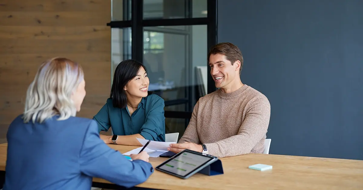 Wealth manager meeting a client at a desk in a modern office