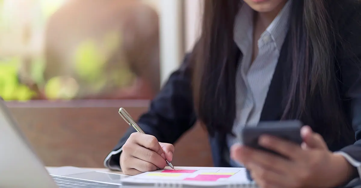 An adviser meeting a client at a desk in a small regulated firm