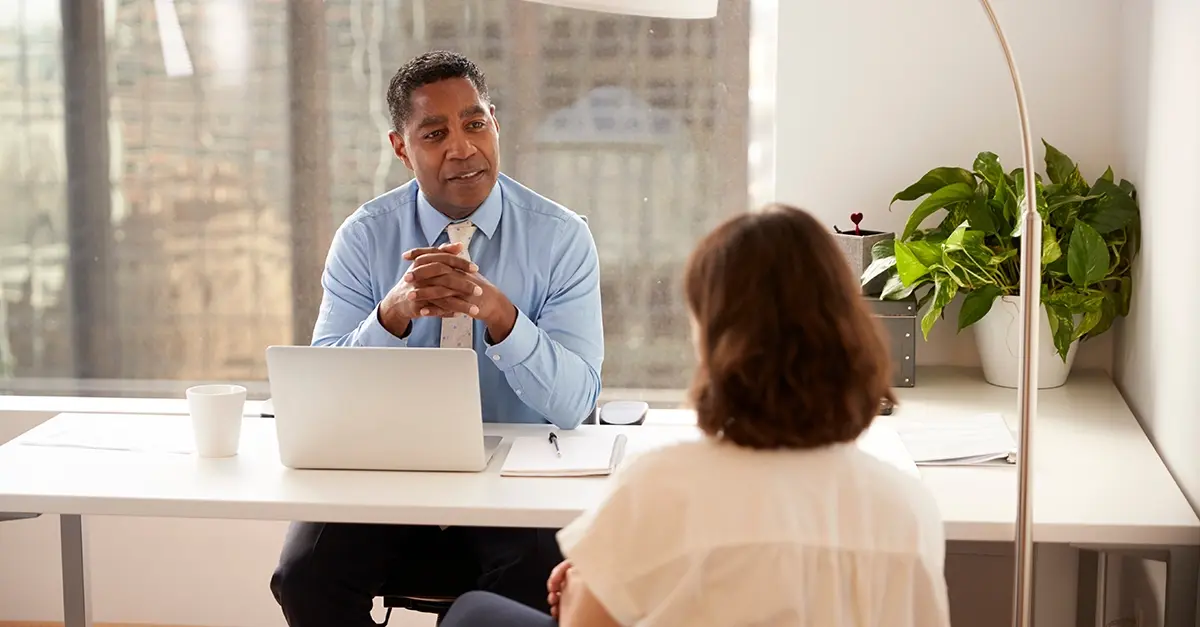 Financial adviser meeting a client at a desk in a modern office